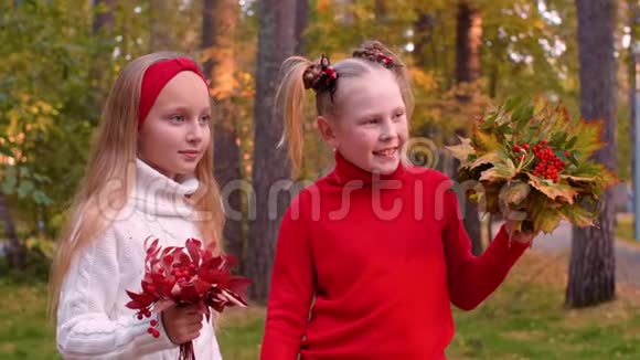 欢快的女孩捧着秋叶和玫瑰花束的肖像视频的预览图