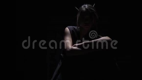 神秘的女人头发上有筷子在黑暗中摆姿势视频的预览图