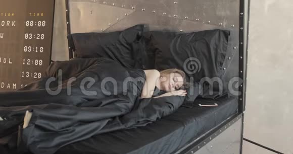 美丽浪漫的女人躺在她房间里的床上慢动作视频的预览图