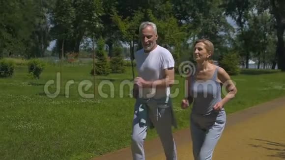成熟的情感伴侣在公园慢跑活跃而充满活力慢节奏视频的预览图