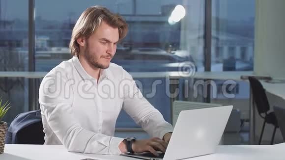 现代有吸引力的商人用笔记本电脑在办公桌上工作的画像视频的预览图