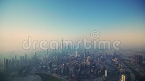 无人驾驶飞机在清晨雾日出的迪拜市中心的未来摩天大楼塔楼上空飞行视频的预览图
