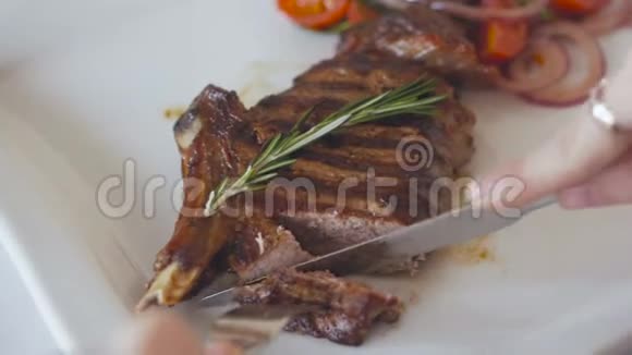 在餐馆里用刀叉吃烤牛排的女人的手的特写视频的预览图