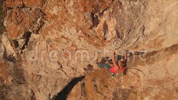 空中射击年轻勇敢的女人登山者爬上岩石断裂跌倒并挂在安全绳上慢动作视频的预览图