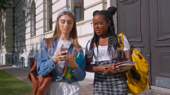两位跨国女性朋友的户外肖像夏天女孩在公园里散步学生生活方式视频的预览图
