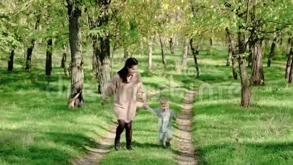 快乐的妈妈和小男孩在秋天公园玩美丽的女人在户外抱着她的小儿子视频的预览图