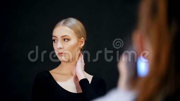 工作室里的模特一位年轻的金发女郎为摄影师摆姿势视频的预览图