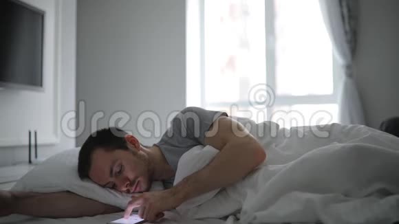 躺在床上拿着手机的男人视频的预览图