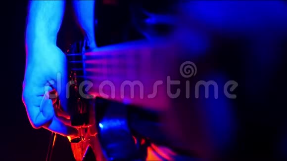吉他手曲和开始演奏他的吉他在明亮的霓虹灯照明视频的预览图