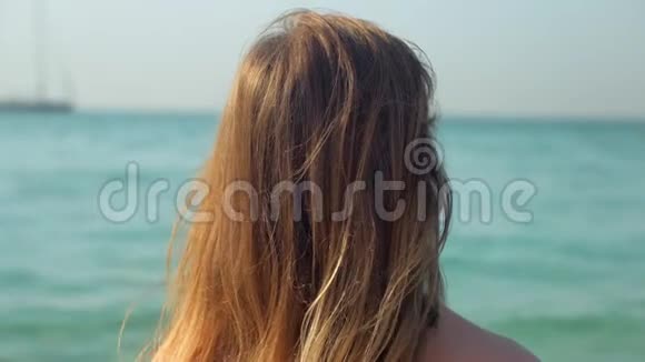 孤独浪漫的金发女人在阳光明媚的日子里看着大海的地平线视频的预览图