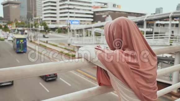 雅加达市中心的一座桥上站着一个年轻而悲伤的穆斯林女孩印度尼西亚视频的预览图