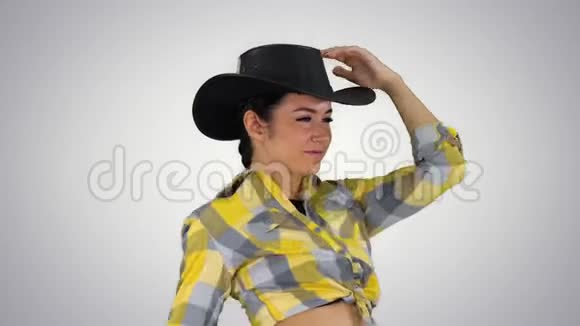 年轻的女牛仔在渐变背景下跳舞视频的预览图