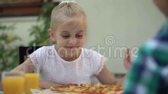 微笑的女孩看着比萨饼选择最好的切片家庭食品传统视频的预览图