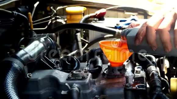 汽车机械师把新的油润滑剂注入发动机汽车维修概念视频的预览图