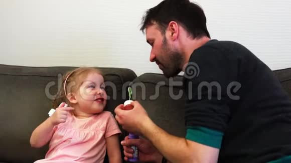 一位父亲慢吞吞地把肥皂泡吹到女儿鼻子上孩子笑了视频的预览图