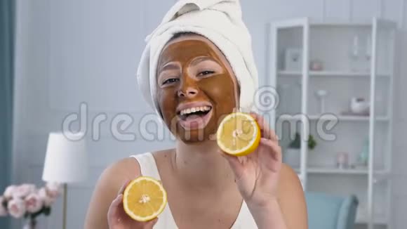 一张迷人的年轻女人的肖像脸上戴着两个半柠檬和棕色面具视频的预览图