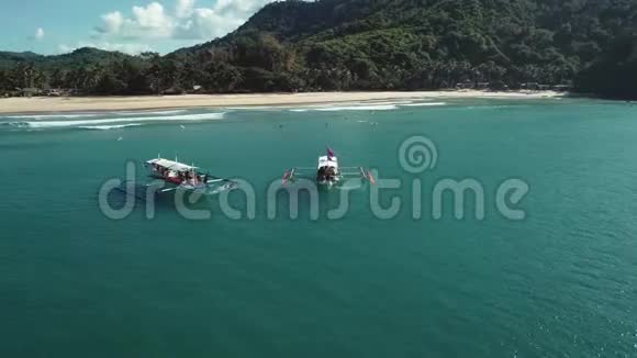 空中拍摄的两艘菲律宾旅游船漂浮在绿松石的原始水域菲律宾巴拉望岛视频的预览图