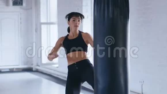 拳击职业运动员女子在健身房踢拳袋跆拳道女子体操训练视频的预览图