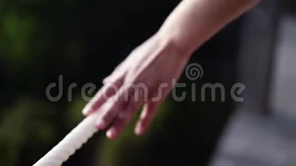 女人走在木制走道上时她的手碰到一根白色的绳子大波克效应视频的预览图
