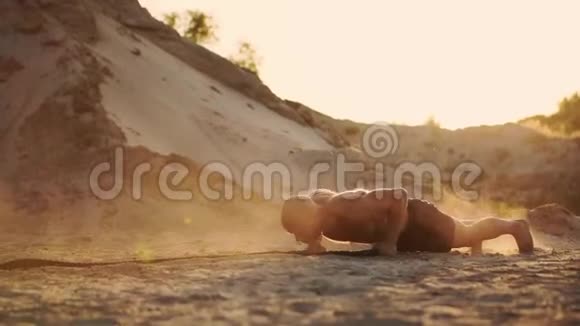 男子运动员在沙滩上做推UPS在地面上打绳子在阳光下在沙滩上做循环训练视频的预览图