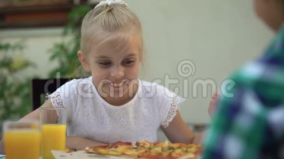学龄前女孩选择和吃最喜欢的意大利披萨享受美味的食物视频的预览图