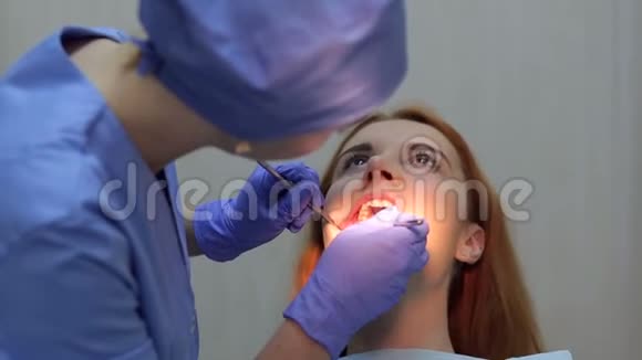 穿着蓝色制服的诊所里一个开朗可爱的女医生牙医的肖像视频的预览图