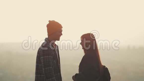 在山里恋爱的情侣徒步旅行者男人和女人站在山上手牵手视频的预览图