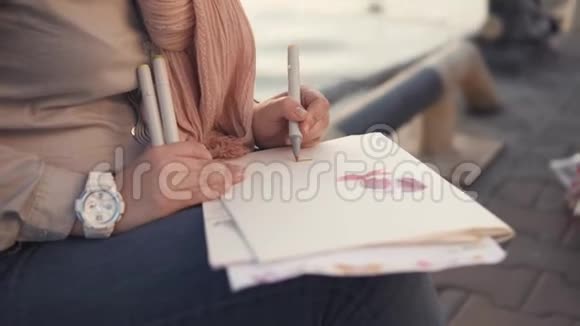 一个女人的手紧紧靠近大海一个女人拿着一支笔视频的预览图