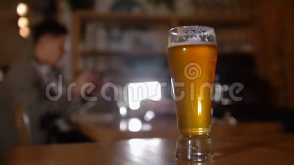 戴眼镜的胡子男在酒吧和他的朋友聊天餐厅把注意力集中在啤酒杯上视频的预览图