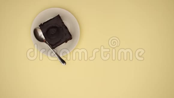 黄色背景下的咖啡蛋糕和记事本停止运动视频的预览图