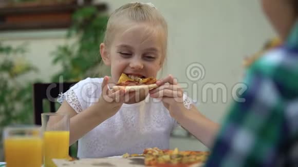 女孩和哥哥在咖啡馆里吃披萨庆祝生日最喜欢的食物视频的预览图