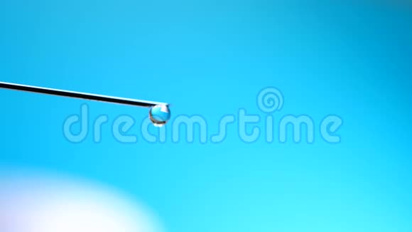 带液体药物滴在蓝底的注射器针药视频的预览图
