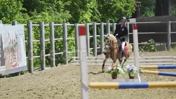 马一位年轻的女子骑着一匹小马驹在马术比赛中表演视频的预览图