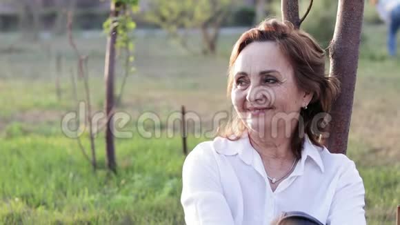 美丽快乐的老妇人在夏天公园玩得很开心视频的预览图