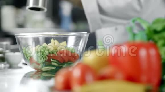 厨房餐厅的厨师胡椒色拉特写双手放着蔬菜视频的预览图