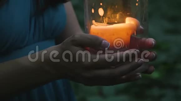 晚上女孩们的手在森林里拿着燃烧的蜡烛视频的预览图