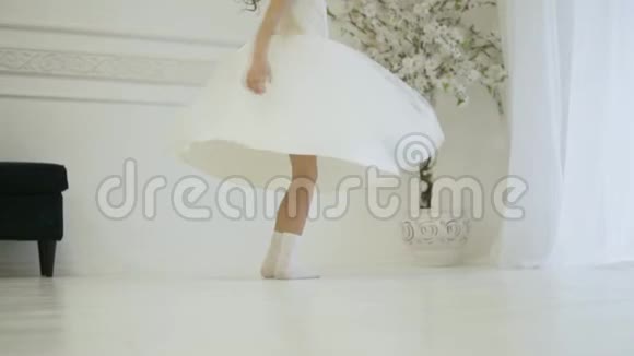一个穿着优雅的白色连衣裙的女孩在舞蹈中旋转视频的预览图