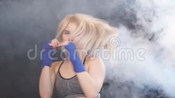 漂亮的金发女拳击手在拳击绷带中摆出防守拳击手的姿势慢动作的肖像视频的预览图