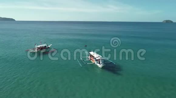 空中拍摄的两艘菲律宾旅游船漂浮在绿松石的原始水域菲律宾巴拉望岛视频的预览图