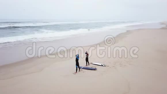 年轻一对友好的冲浪者在入海前锻炼身体视频的预览图