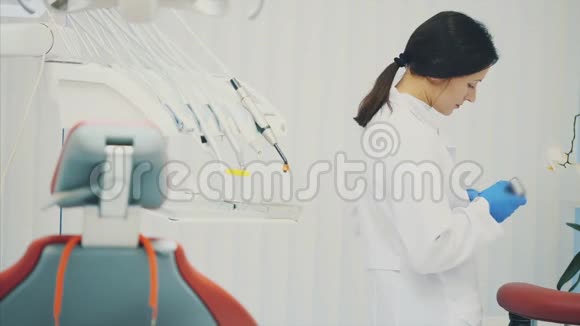 一个好的专家是牙医一位身穿白色礼服的年轻美女的肖像站在牙科里视频的预览图
