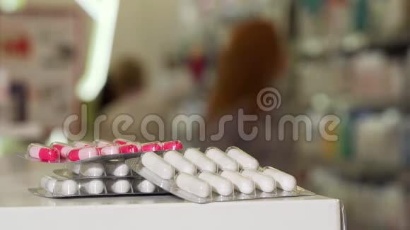 从药房柜台上吸起水泡药丸的女人有选择地集中注意力视频的预览图