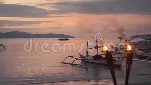 菲律宾海滩上带火把的浪漫日落视频的预览图