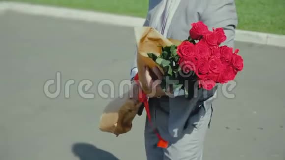 男人带着一束玫瑰等待一个女孩浪漫的或第一次约会求婚视频的预览图
