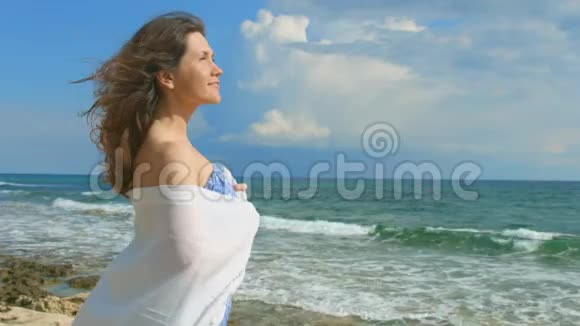 美丽的女人在海滩上做梦美丽的海浪上岸大自然视频的预览图