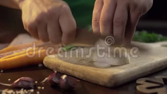 厨师在厨房的木板上切洋葱生蔬菜烹饪食品的特写镜头全高清道具视频的预览图