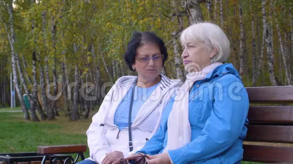 两位坐在公园长椅上的高级妇女视频的预览图