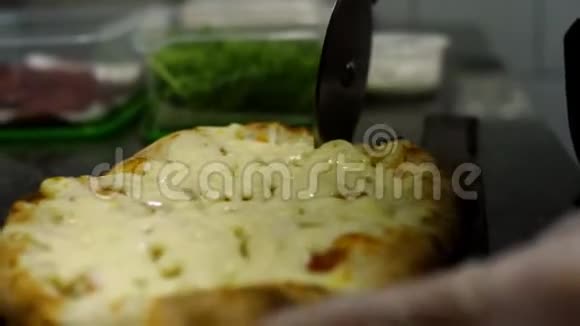 特写厨师用圆刀切披萨框架男人用特制的圆刀切新鲜准备的披萨片视频的预览图