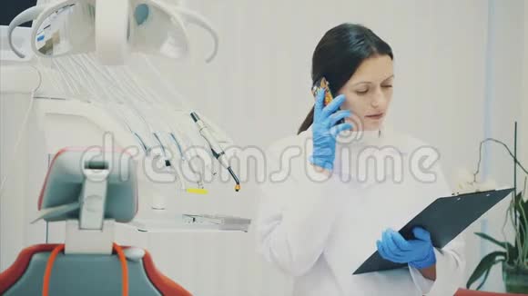 一个好的专家是牙医一位身穿白色礼服的年轻美女的肖像站在牙科里视频的预览图