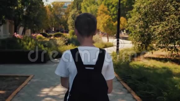 那个男孩拿着背包走在街上一个孩子周游世界视频的预览图